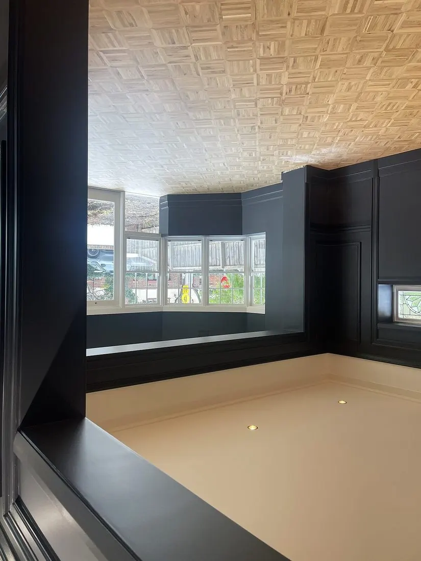 Deep navy panelled feature walls with ornate ceiling in a Melbourne home